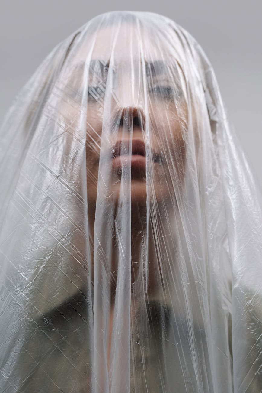 unrecognizable woman covered with plastic bag